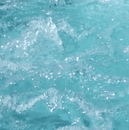 Close-up view of bubbling blue water in a cold plunge tub, with bubbles and movement visible on the surface—perfect for pairing with a barrel sauna or outdoor sauna experience.